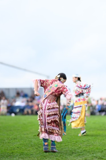 Valerie Leith dancing, seen from behind, jingle dress fringe in motion