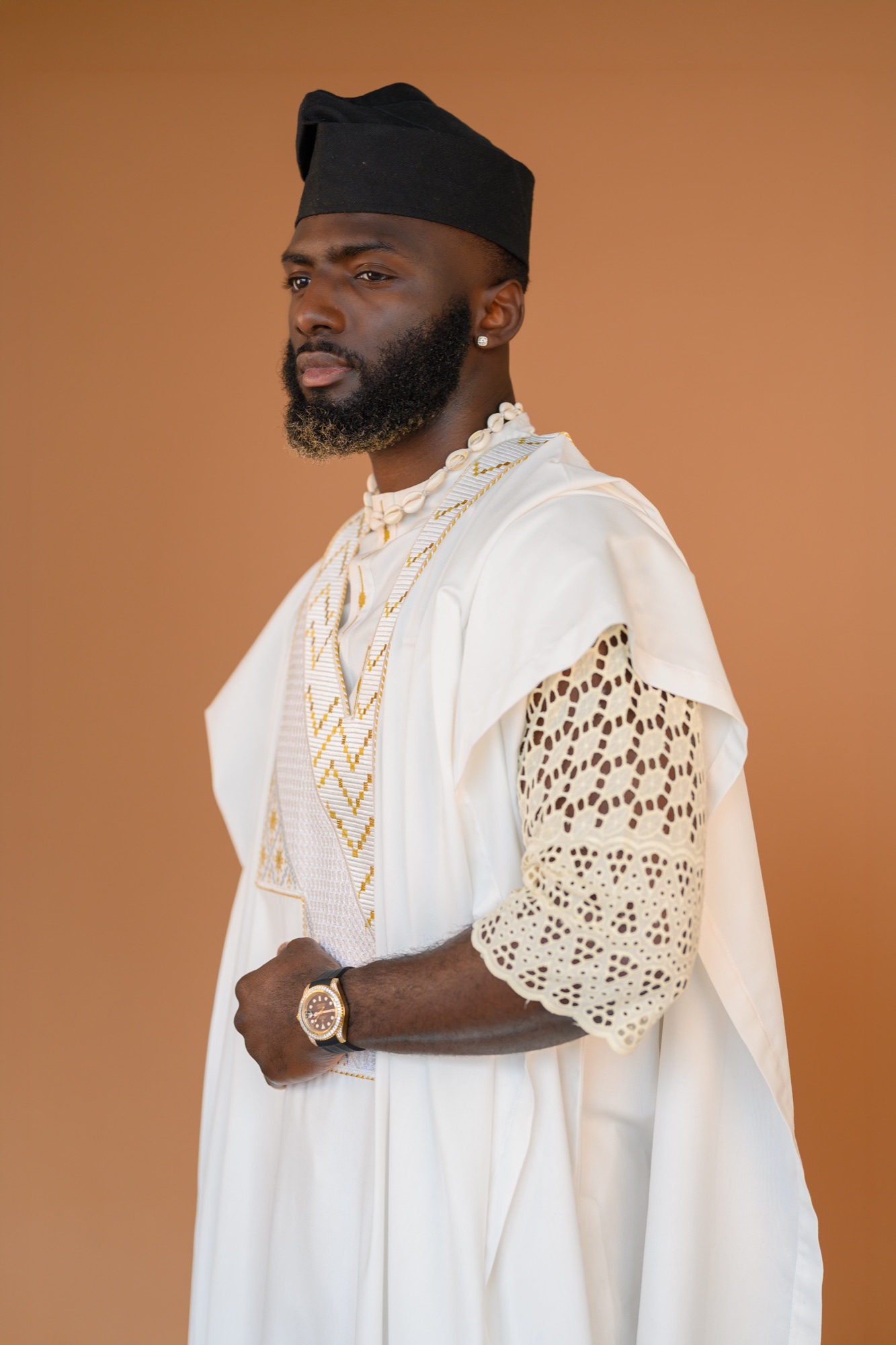 Portrait of Nelson Igbinovia in white agbada with cowrie shells