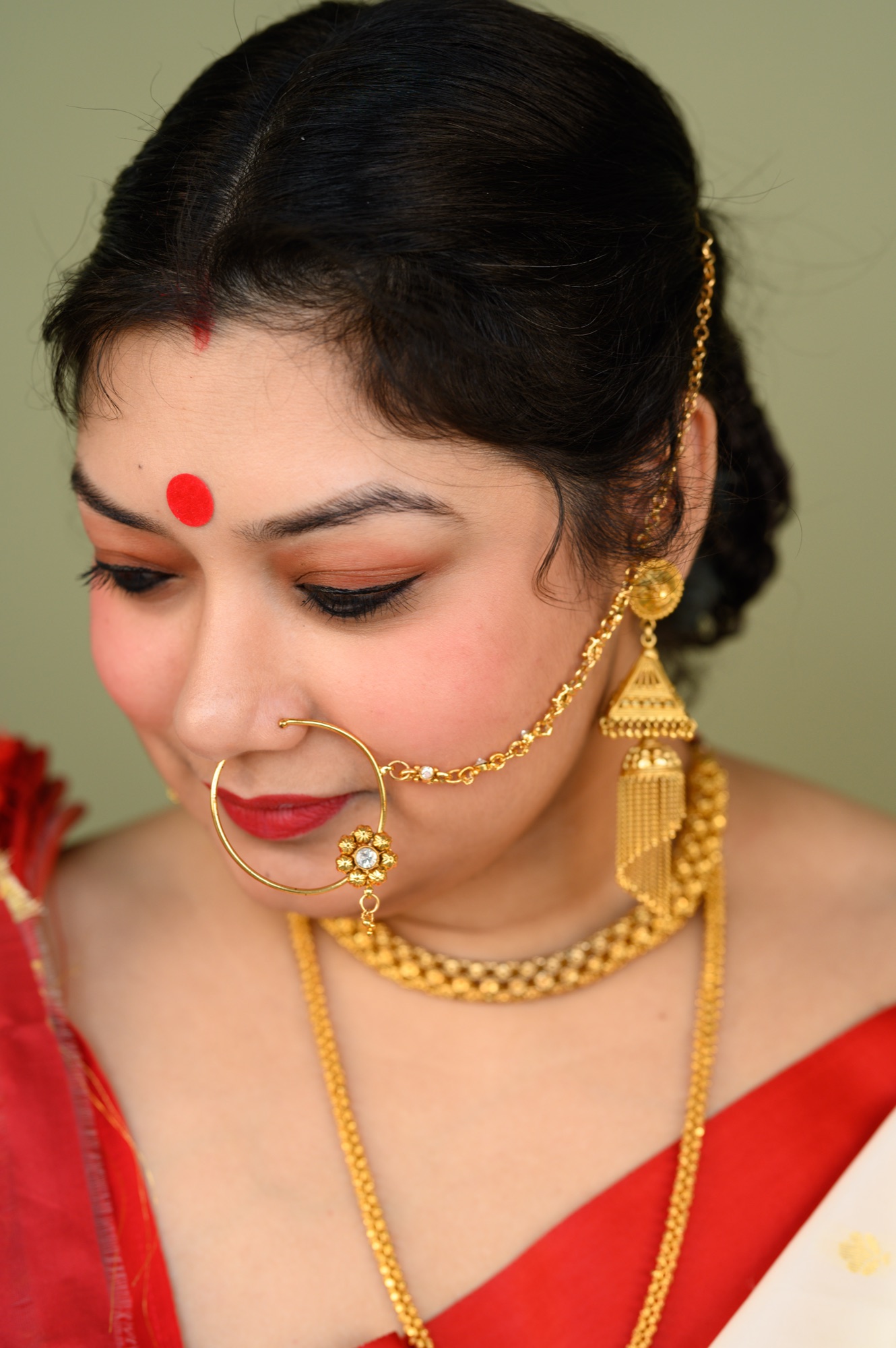 Close profile of Debanjana Chatterjee's nath and gold jewelry