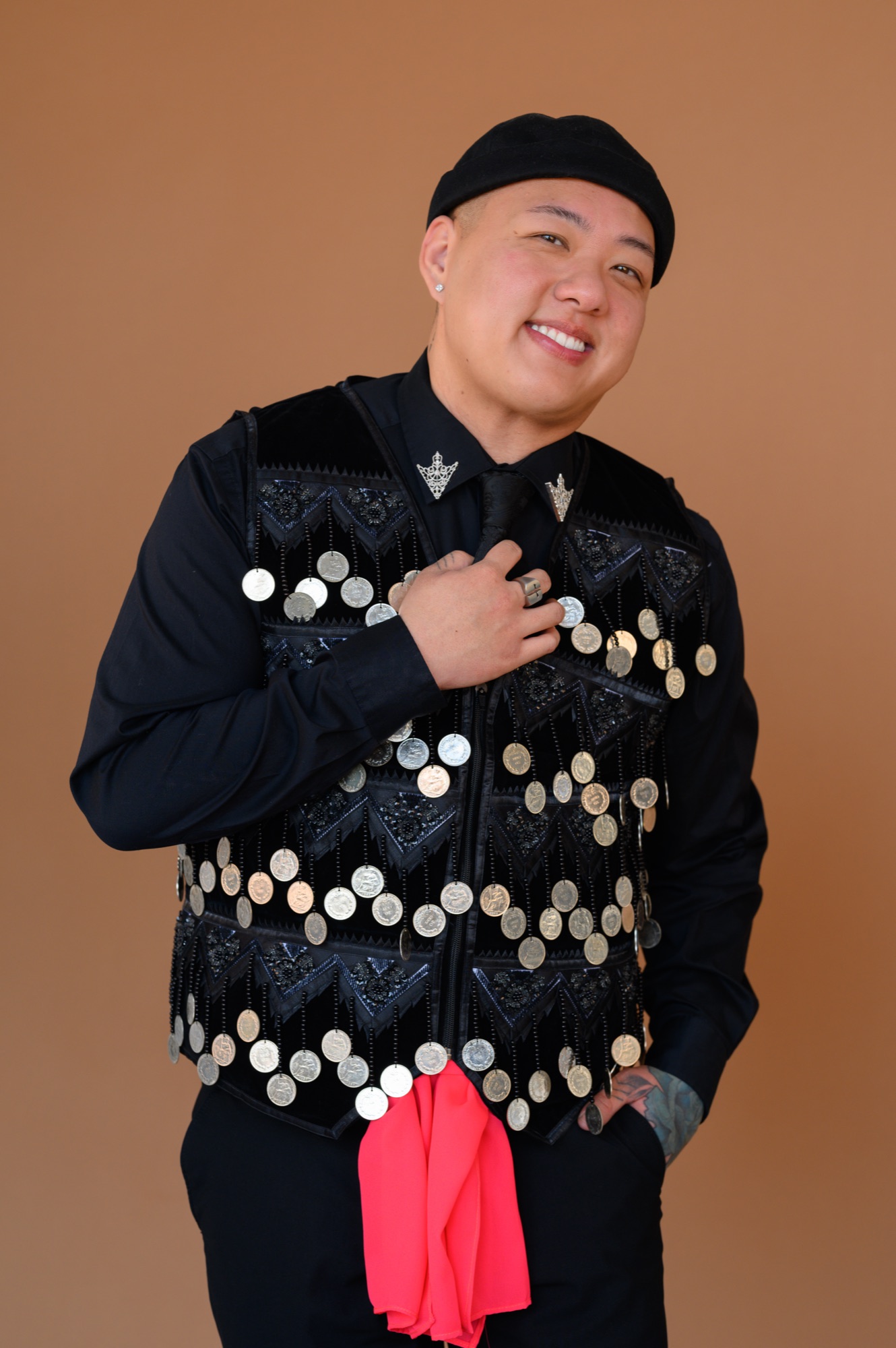 Portrait of Remmus Xiong in a black Hmong vest with silver coins