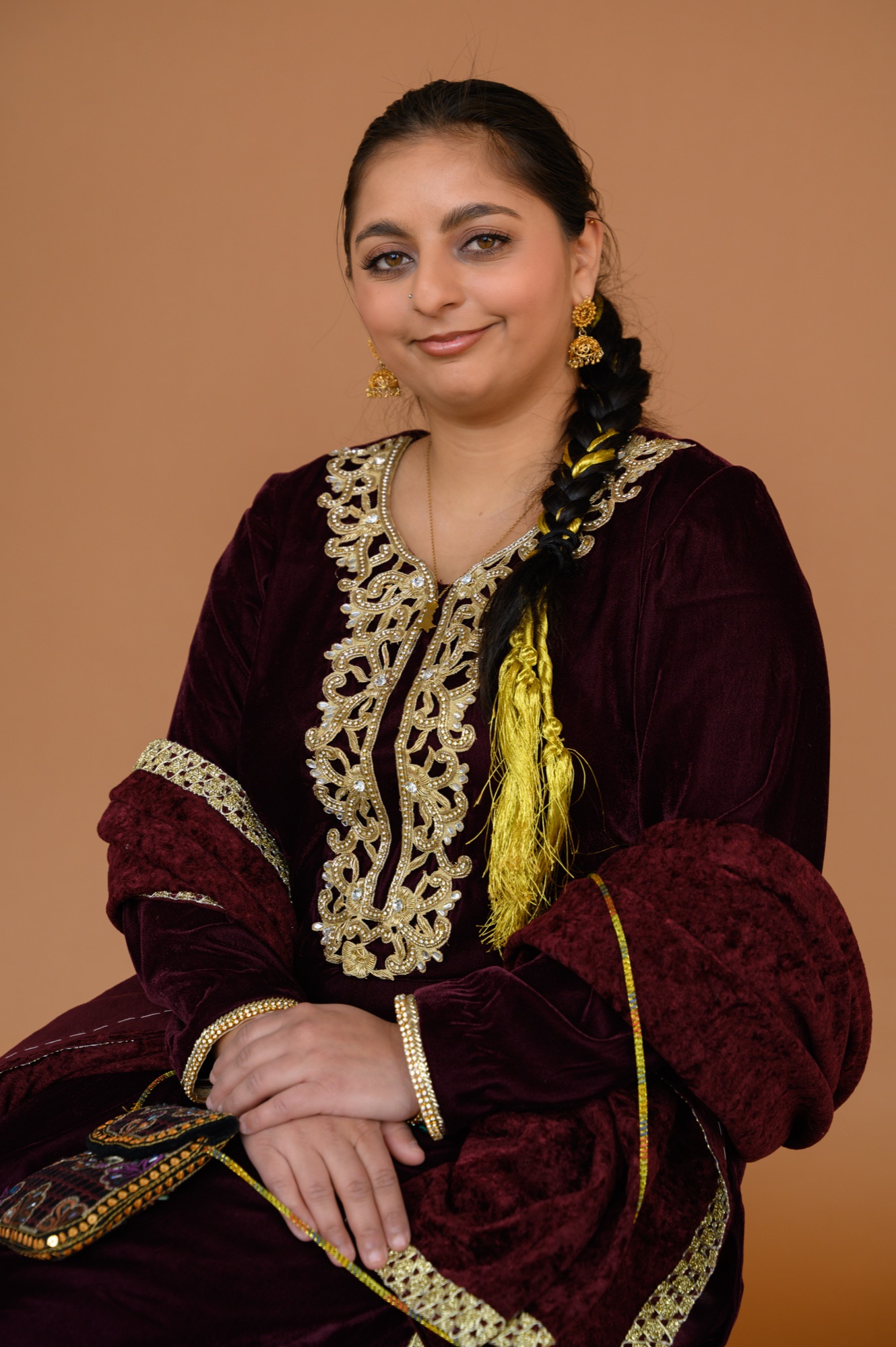 Portrait of Aliza Mashadi in a maroon velvet shalwar kameez
