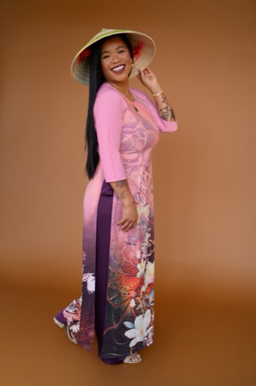 Thuba Nguyễn in a pink áo dài, holding the brim of her nón lá